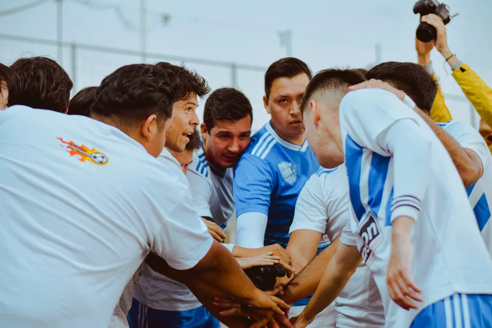 Football players come together in a team huddle
